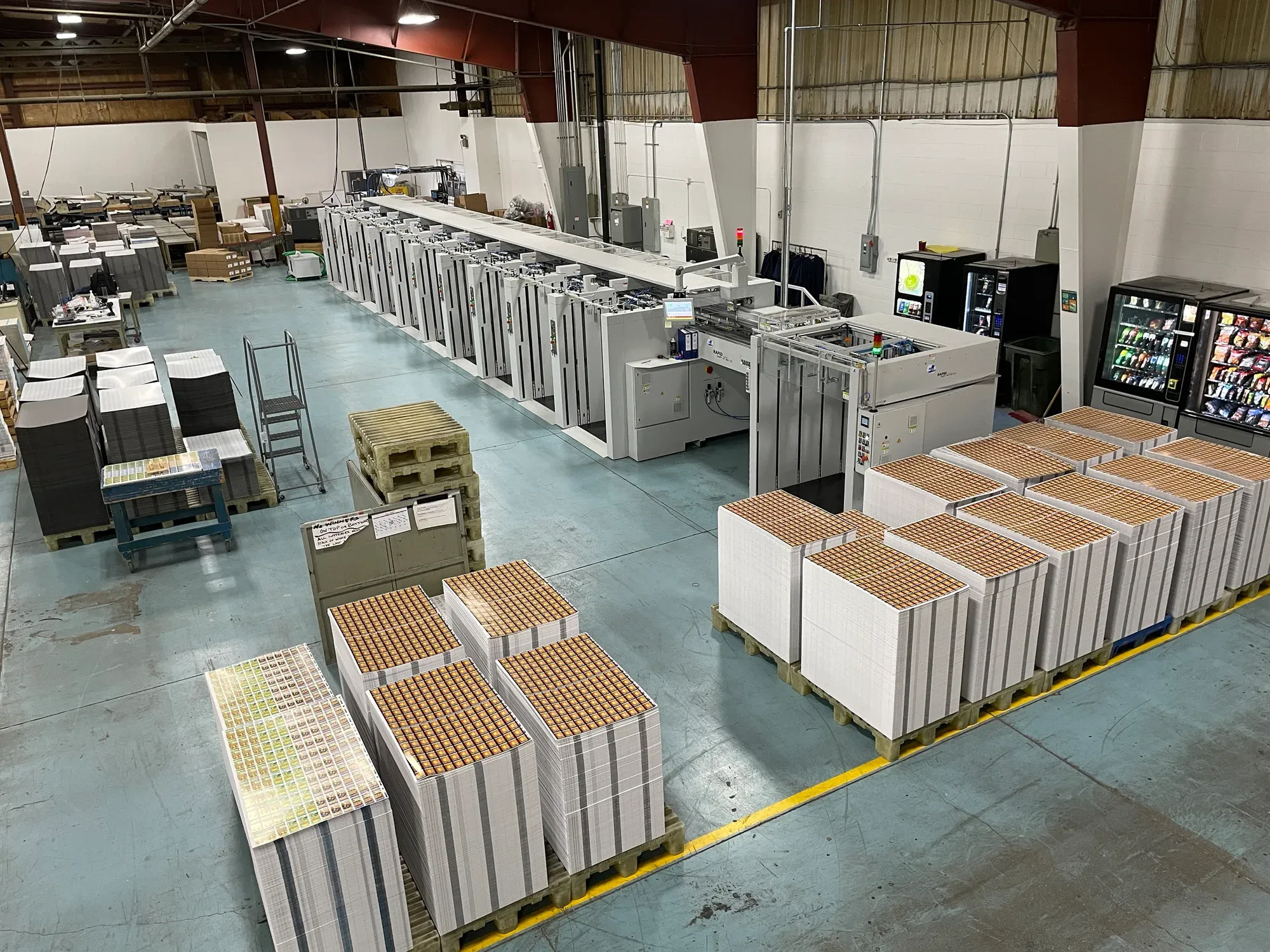 MKW GIANT collator with collated carton sheet stacks on pallets ready for die cutting